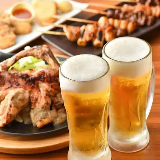焼鳥の盛り合わせと冷たい飲み物が並ぶテーブル
